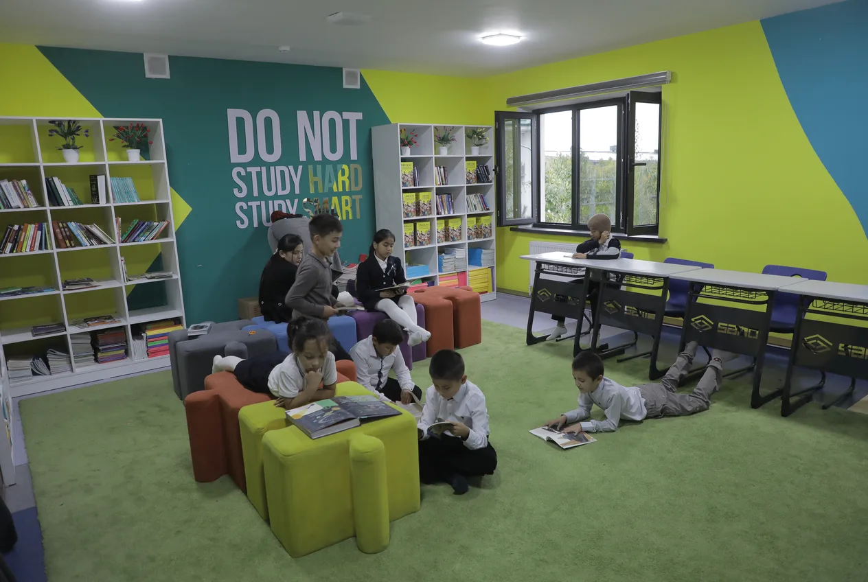 Study Smart shiorli maktab kutubxonasi: oʻquvchilar qulay pufiklarda kitob mutolaa qilmoqda